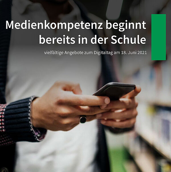 junger Mann hält vor einem Bücherregal ein Smartphone in der HandEin 
