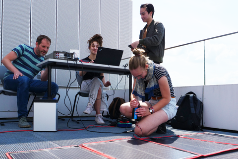 RenewableSkills Vier Personen testen mobiles Laden mit Solarpanelen auf dem HTWK-Dach