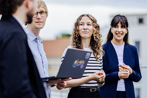 Berufseinstieg Vier Personen in Business-Kleidung im Gespräch miteinander