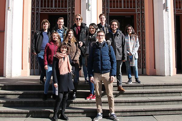Eine Gruppe von Studierenden steht auf einer Treppe