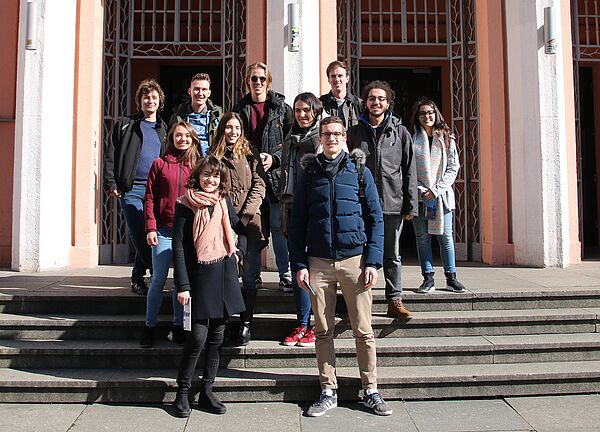 Eine Gruppe von Studierenden steht auf einer Treppe