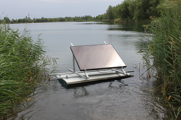 Ein Abbildung umfunktioniertes Rotorblatt als Schwimmsegment mit einem darauf befestigten Photovoltaik-Panel auf einem See schwimmend