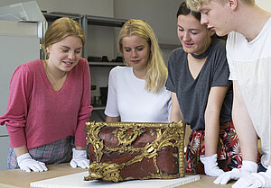 Schnupperwochenende Museologie - interessierte Schüler schauen sich ein Exponat an