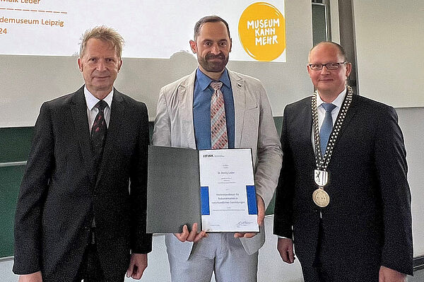 Prof. Mark Mietzner, Rektor und Prof. Uwe Kulisch, Dekan der Fakultät Informatik und Medien der HTWK Leipzig verleihen Naturkundemuseum-Direktor Dr. Ronny Maik Leder den Ehrentitel samt Urkunde