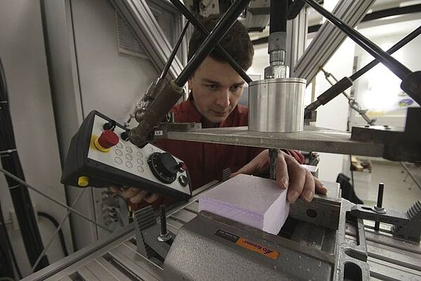 Mann an der parallelkinematischen Laborwerkzeugmaschine