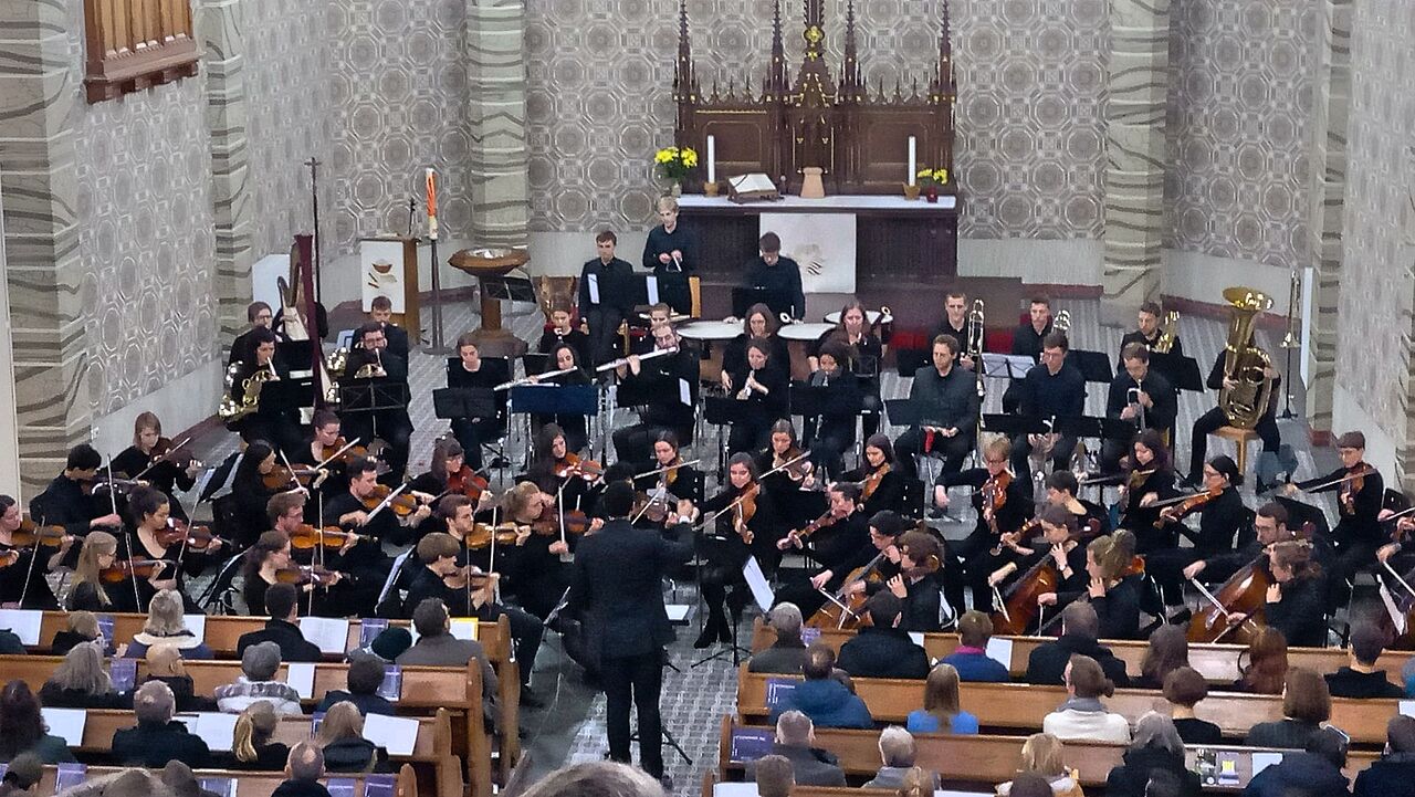 Das Jahresabschlusskonzert in der Lukaskirche. Das HTWK Orchester ist von schräg oben vor dem Altar zu sehen.