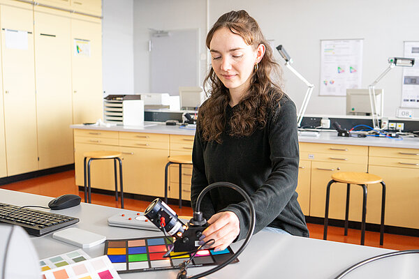 Lena Nicklaus Studentin mit einer Farbkarte im Labor