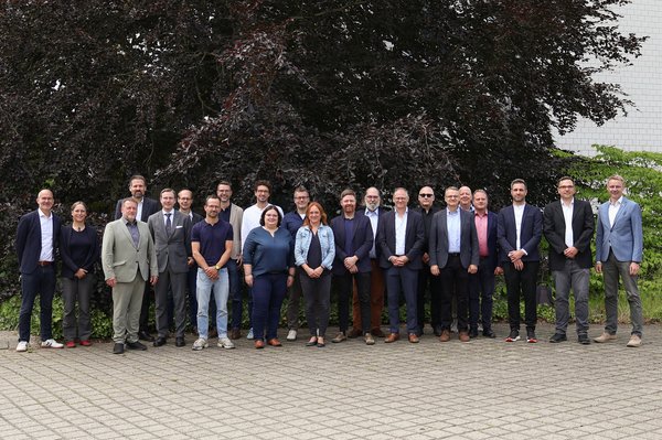 Gruppenbild 30 Personen stehen im Freien für ein Gruppenbild nebeneinander