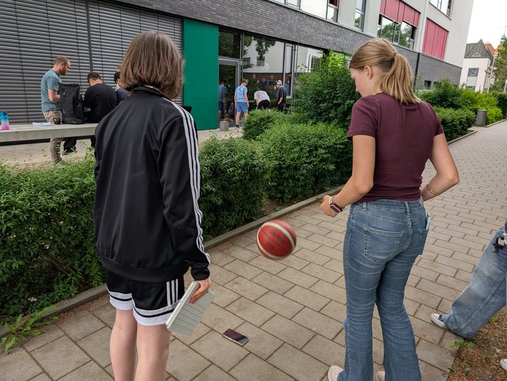 Sport4MINT-Station Bälle Zwei Jugendliche lassen einen Basketball aus der Hand fallen