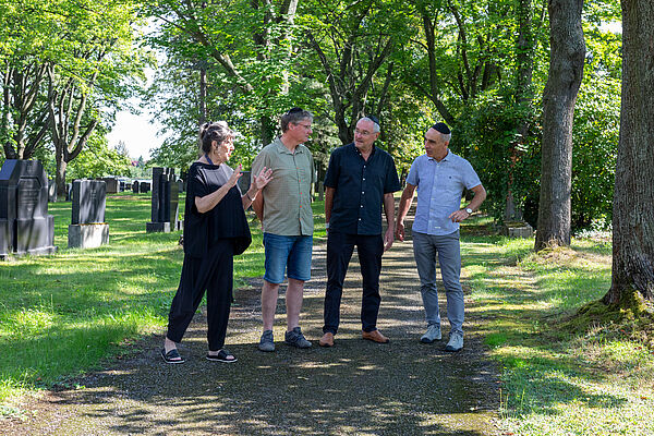 Eta Zachäus, Steffen Held, Prof. Ronald Scherzer-Heidenberger und Prof. Ralf Thiele laufen gemeinsam über den Neuen Israelitischen Friedhof.