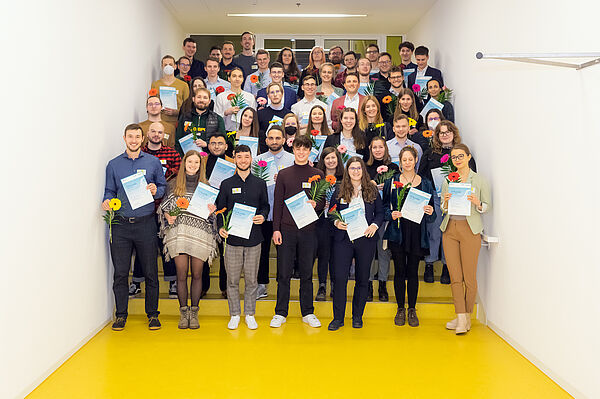 Gruppenbild der freudestrahlenden geförderten Studierenden mit Ukrunde und Blume in den Händen.