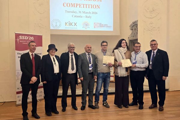 8 Personen stehen für ein Gruppenbild nebeneinander auf der Bühne