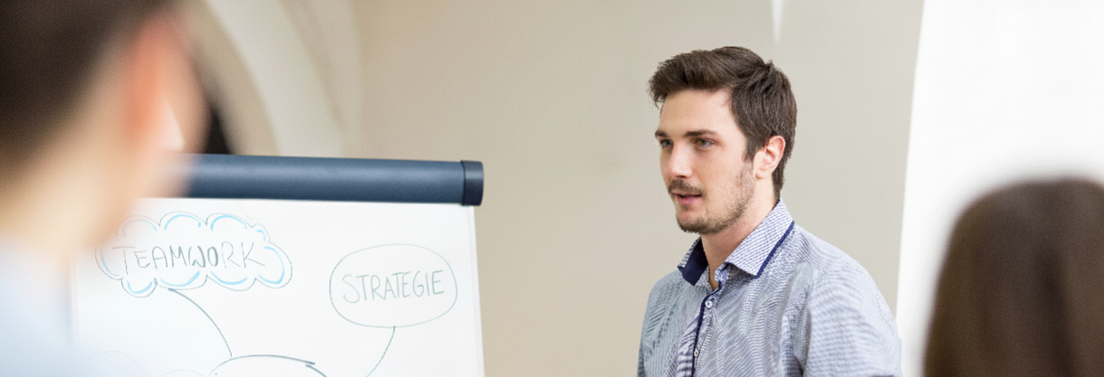 Betriebswirtschaft Master HTWK Leipzig Ein Student erklärt anderen Studierenden etwas am Flipchart.