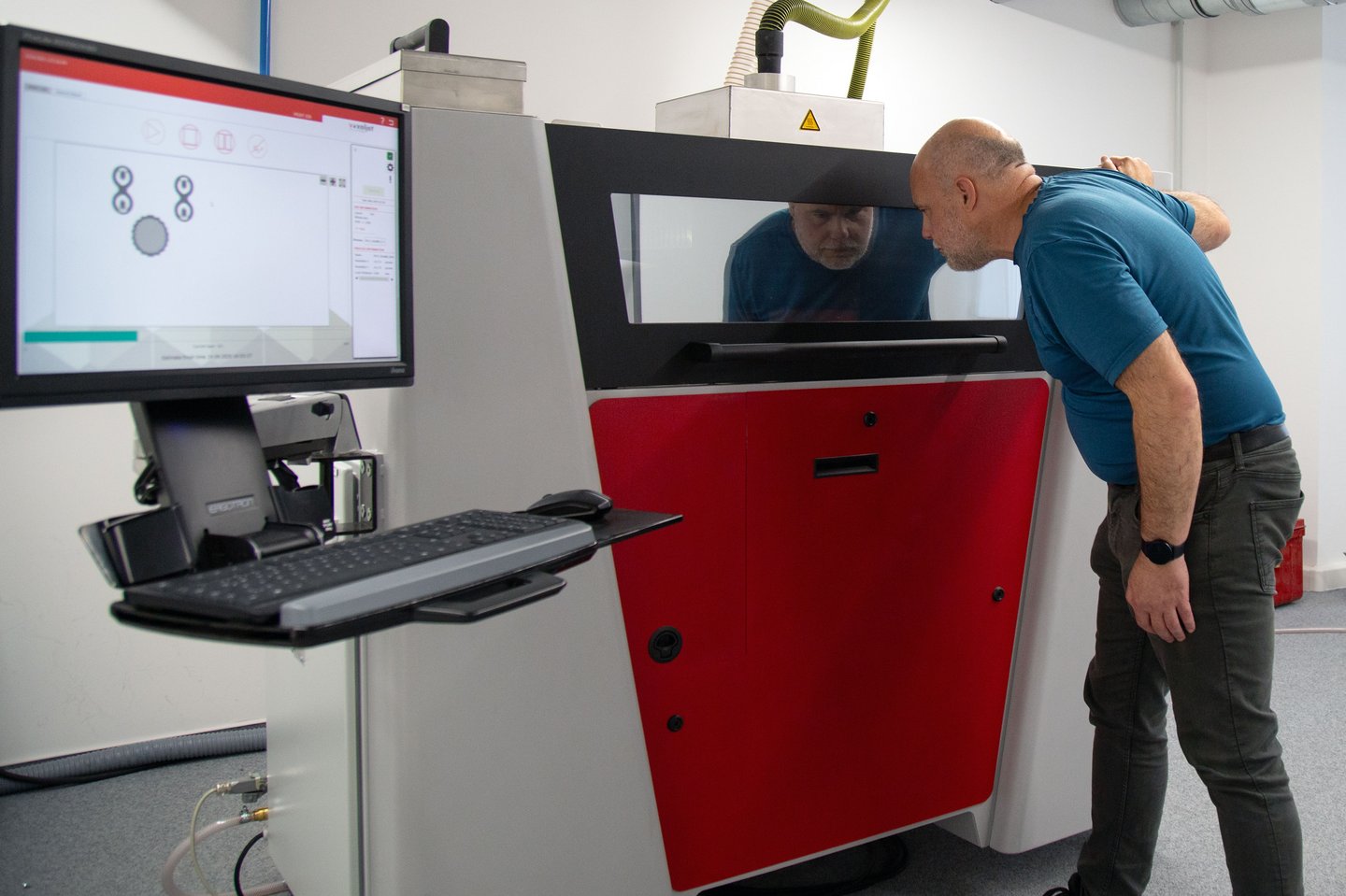 ein Mann schaut in einen Drucker rein