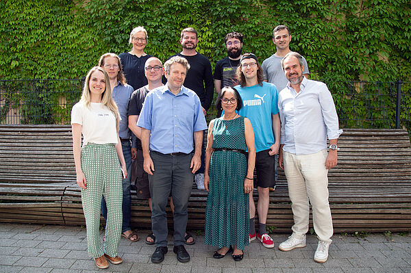 Brasilianische und deutsche Forschende versammeln sich zum Teamfoto vor einer grünen Wand