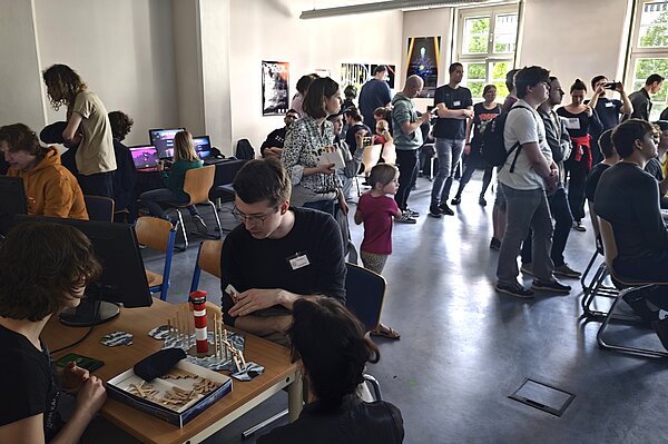 Viele Menschen in Seminarraum spielen zusammen verschiedene Spiele