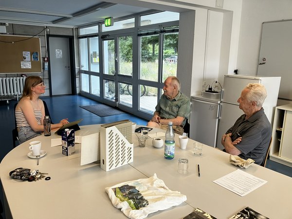Geschichten aus dem Leben: Helen Arens (li.) im Gespräch mit Horst Sahlmann (MItte) und Hans Dachs. (Foto: HTWK Leipzig) junge Frau im Gespräch mit zwei älteren Herren an einem Tisch.