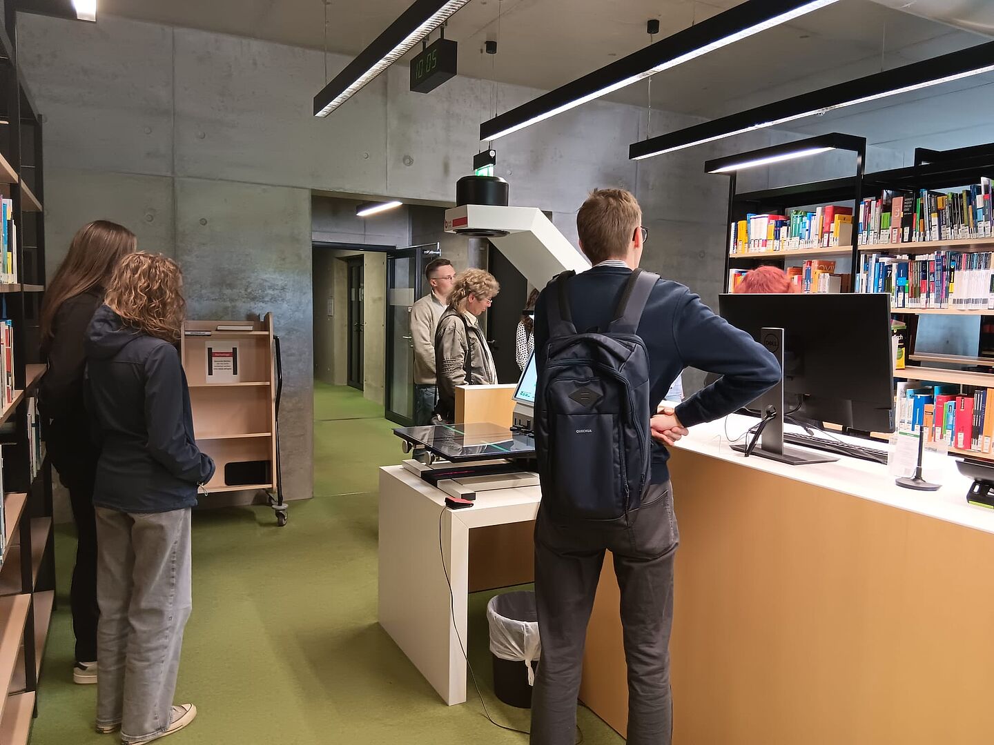 Bibliotheksführung (Foto: FIM) Personengruppe am Tresen einer Bibliothek