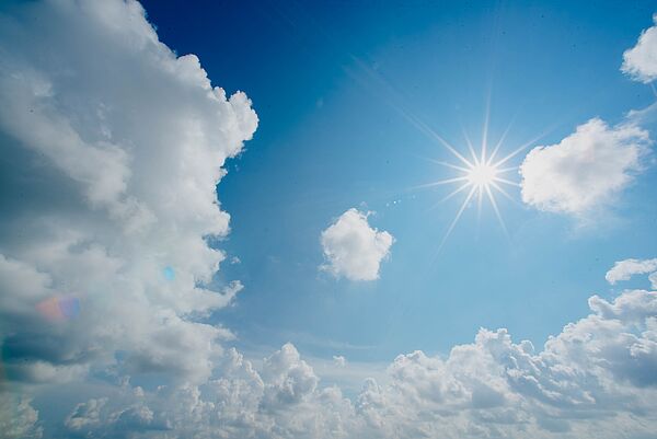blauer Himmel mit Wolken und Sonne