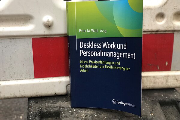 Ein Buch lehnt an einem Bauzaun