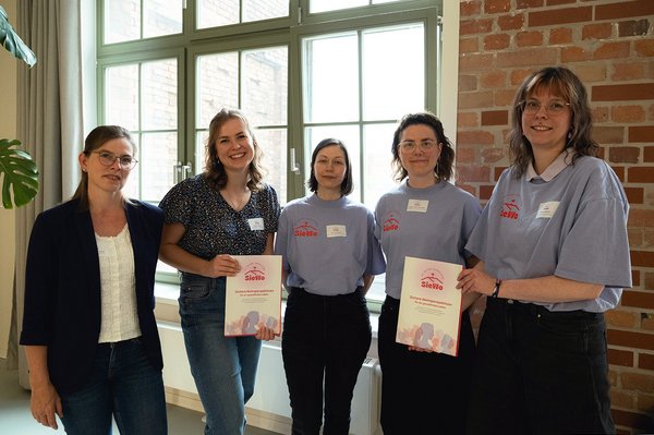 5 Frauen stehen nebeneinander und schauen in die Kamera
