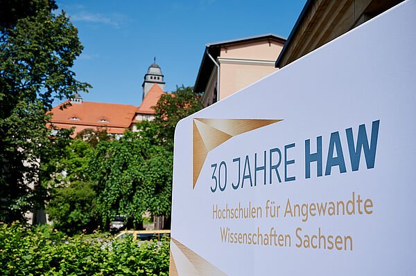 schrifttafel mit Turm im Híntergrund