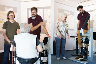 siBUS Zwei Mitarbeiter der HTWK testen die Exoskelette an einer Seniorin und einem Senior