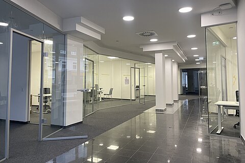 Innenansicht des HTWK City Office Innenansicht des modernen City Offices mit vielen Glaswänden und weißen Säulen.