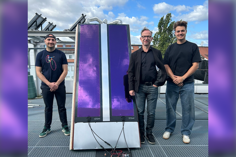 Gruppenfoto, in der Mitte befindet sich ein liafarbenes langes Solarmodul-Prototyp