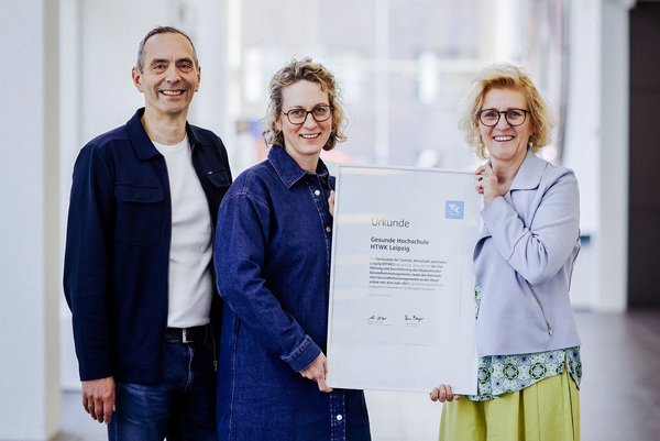 René Berger und Anne Herberger von der Techniker Krankenkasse überreichen Kanzlerin Prof. Dr. Swantje Rother die Urkunde  (Copyright/ Foto: Anne Schwerin)