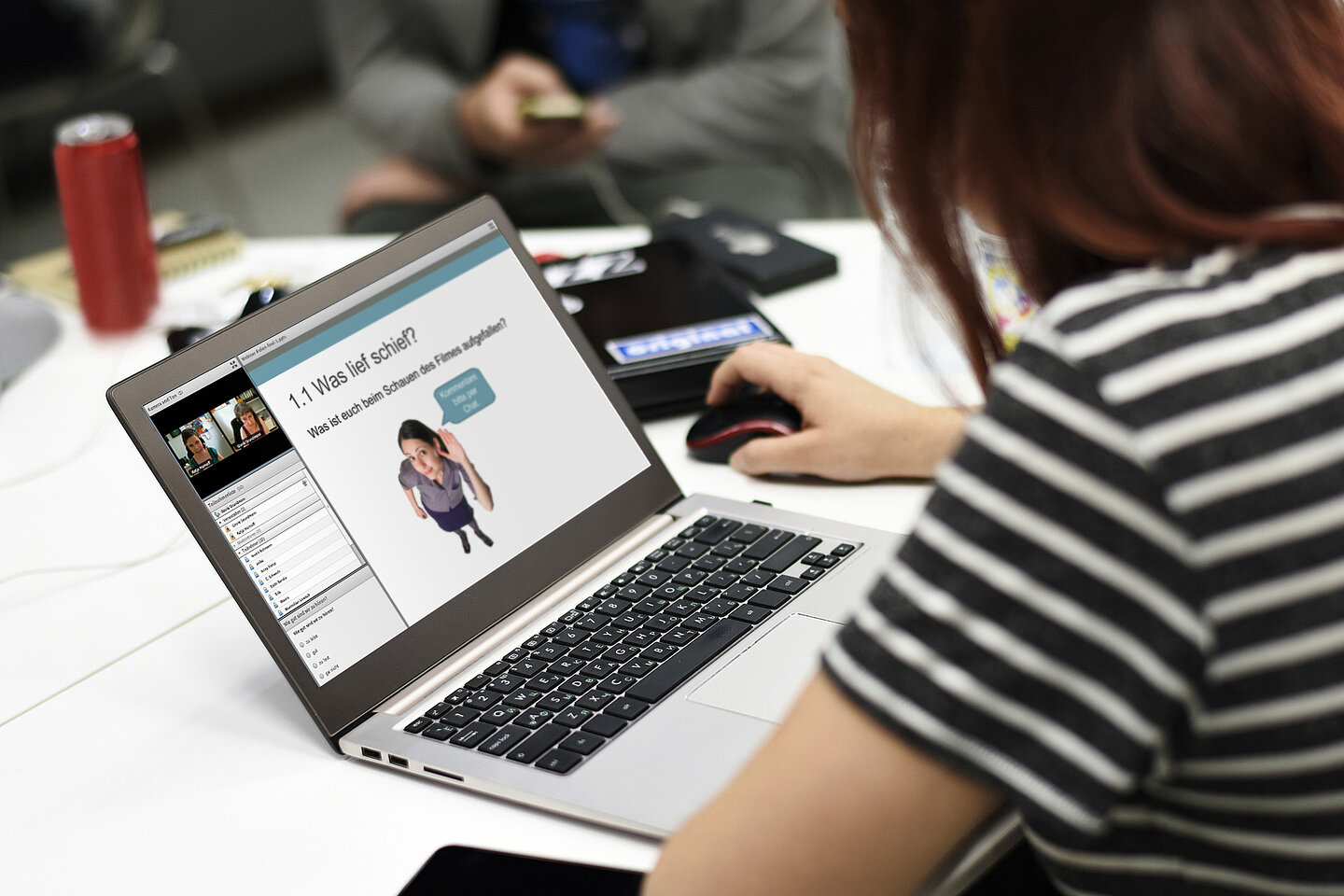 person sitzt am Laptop. Auf dem Bildschirm sind Powerpointfolien zu sehen.