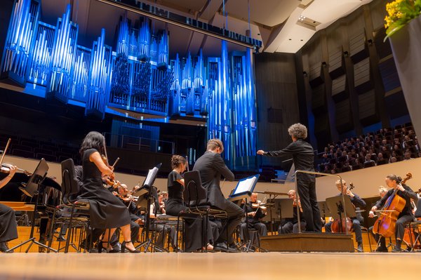 Feierliche Immatrikulation 2026 Orchester spielt auf großer Bühne vor blau beleuchteter Orgel
