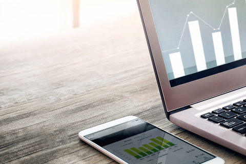 Nahaufnahme eines Smartphones und eines Laptops, die auf einem Tisch liegen