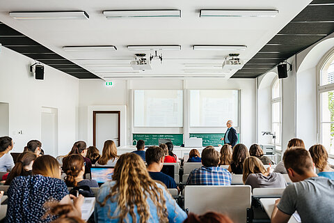 (Foto: feinesbild.de) Studierende sitzen im Hörsaal und folgen einer Vorlesung
