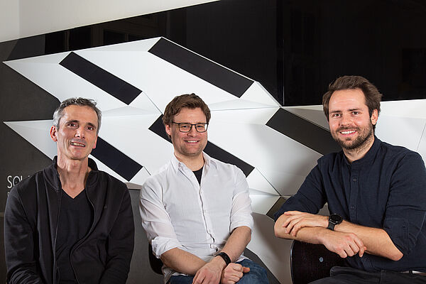 Das Team hinter der Solar-Shell Prof. Frank Hülsmeier, Stefan Huth und Adrian Heller sitzen vor einem Modell der Solar-Shell