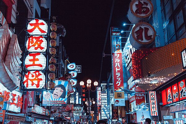 Straßenzug mit Leuchtreklame in japanischer Schrift