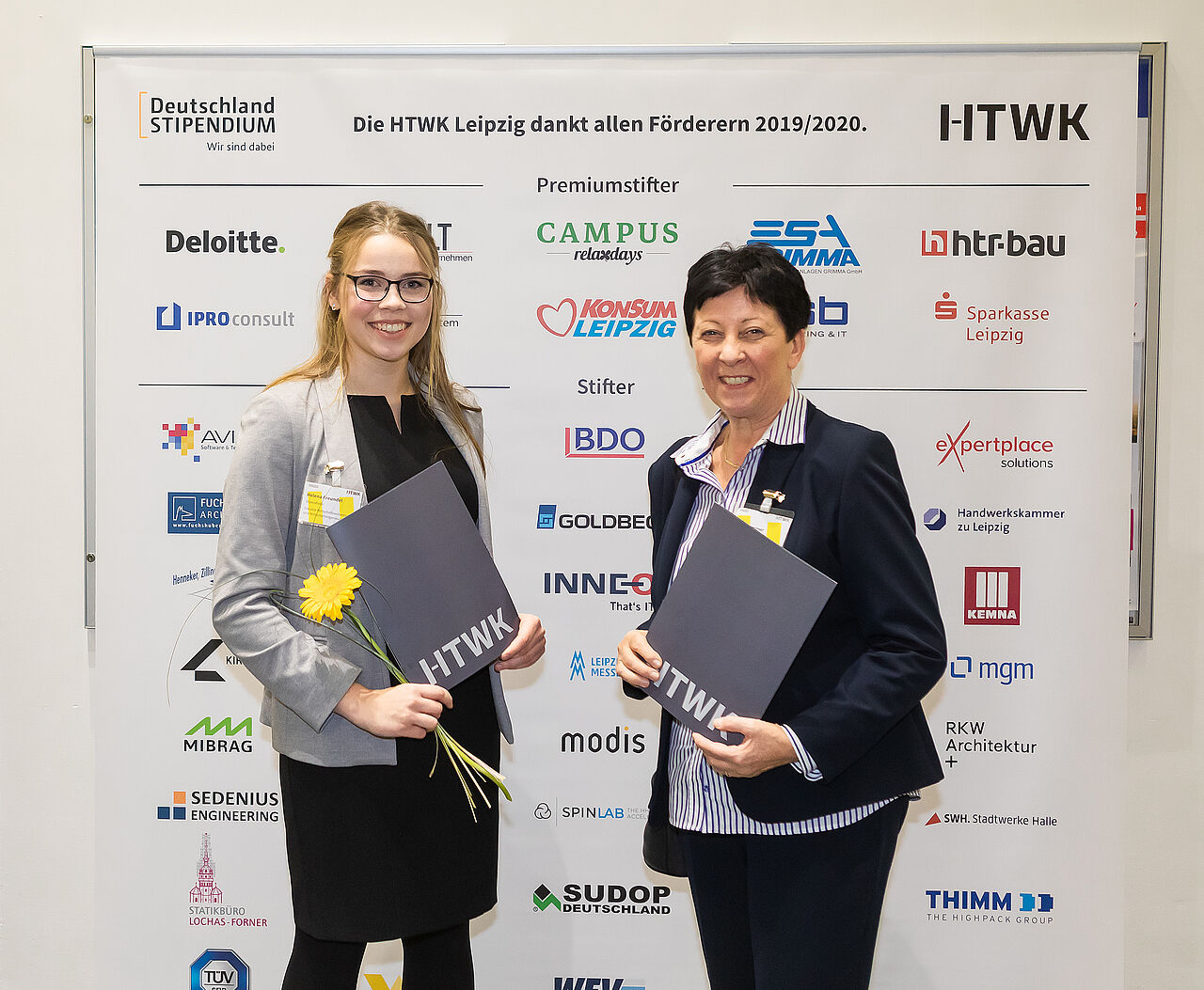 Deutschlandstipendium: zwei Damen vor Logo-Wand