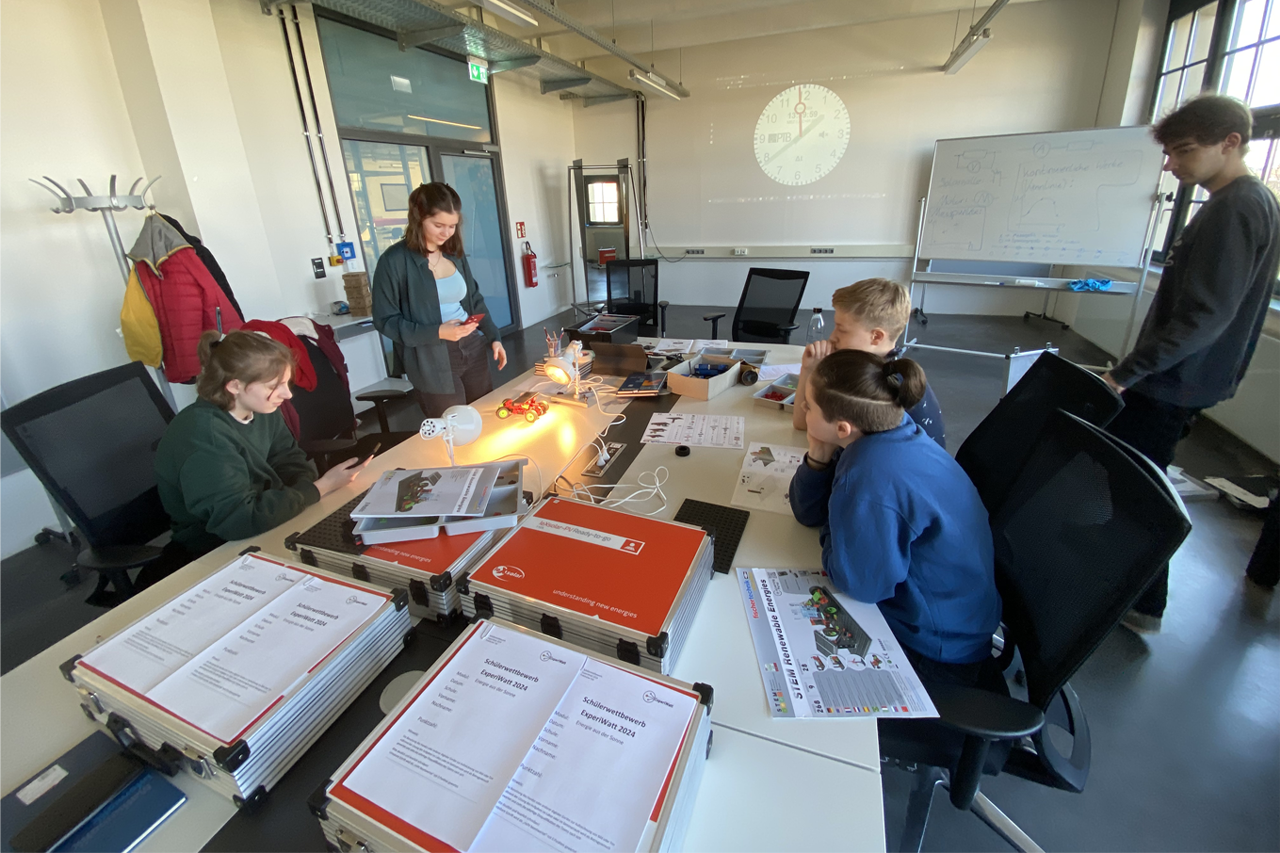 ExperiWatt 2024: zwei Schüler messen an Solarzellen die Sonnenergie bei der VDI GaraGe Leipzig unter Anleitung Dozentin und Dozenten