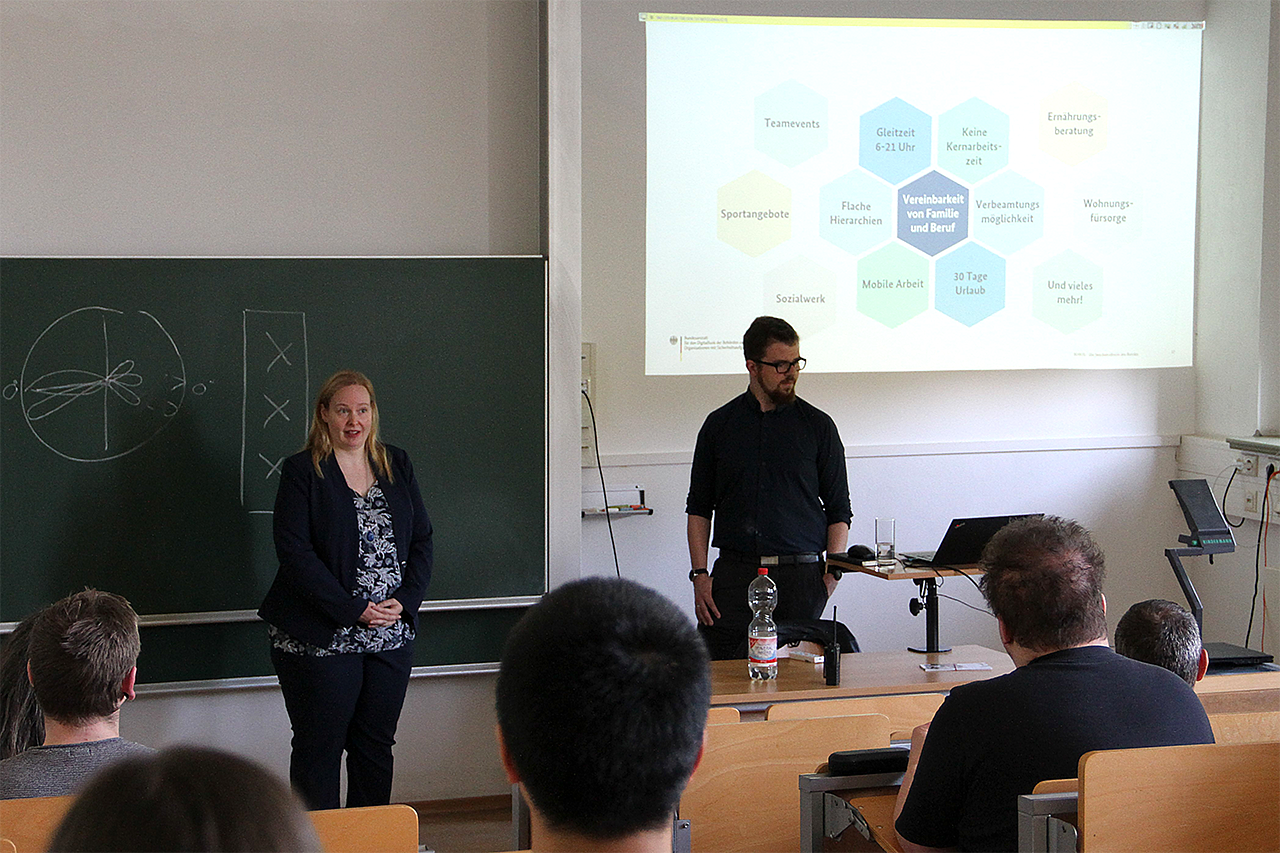 Vortragenden im Seminarraum an der Projektionswand
