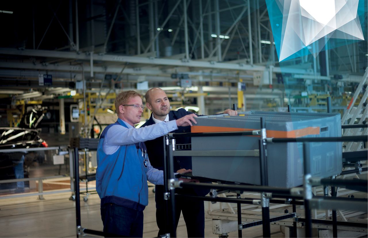 Two employees examine a logistical basket in a warehouse