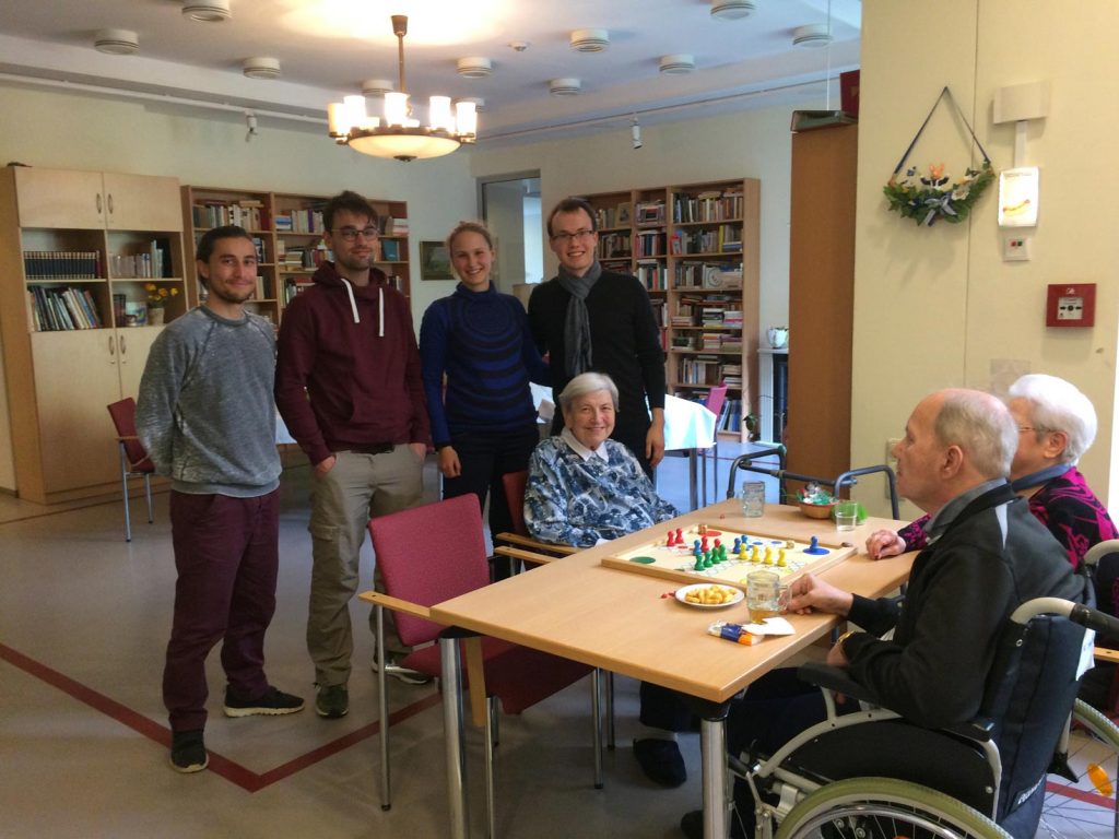 Geselligkeit (Foto: HTWK Leipzig) Auf dem Bild sind vier Stipendiaten des Deutschlandstipendiums zu sehen, welche gerade ältere Damen und Herren im Altenheim besuchen und mit Ihnen unter anderem Mensch-ärgere-dich-nicht spielen.