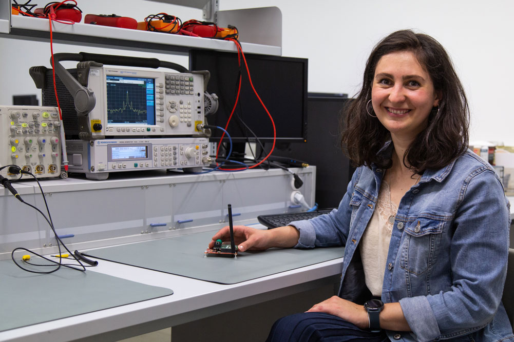 Lydia Schott, Promovendin in der Fakultät ING, hält in ihrer Hand eines ihrer Forschungsobjekte, einem ihrer Forschungsobjekte, den Prototyp eines Funkmoduls mit Wake-up Receiver 