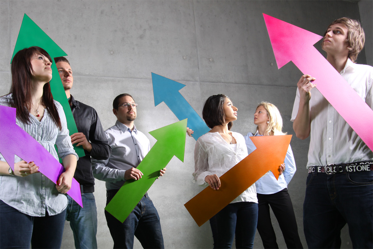 Six people hold different colored arrows pointing upwards in their hands