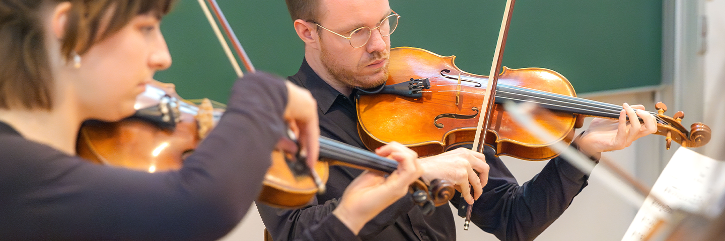 Nahaufnahme von Studierenden, die Musikinstrumente spielen