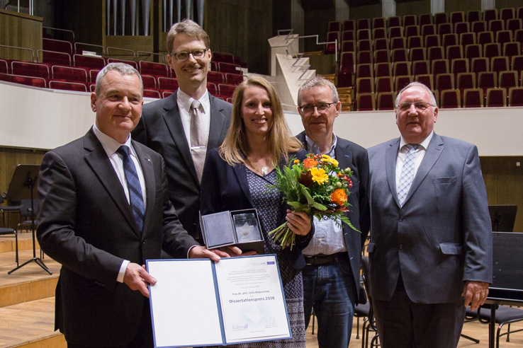 Übergabe Dissertationspreis der HTWK Stiftung 2016 Übergabe Dissertationspreis der HTWK Stiftung 2016. Fünf Menschen stehen in Anzügen im Bild. Die Preisträgerin hält einen Blumenstrauß und den Preis in den Händen.