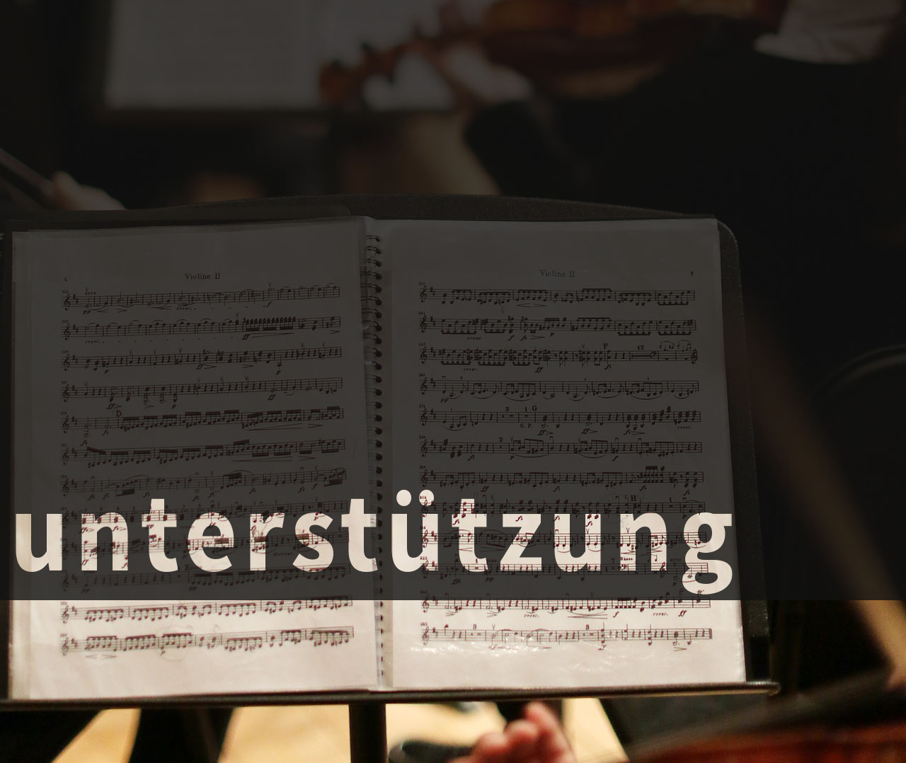 Auf das Foto eines Notenheftes wurde der Schriftzug "Unterstützung" gelegt 