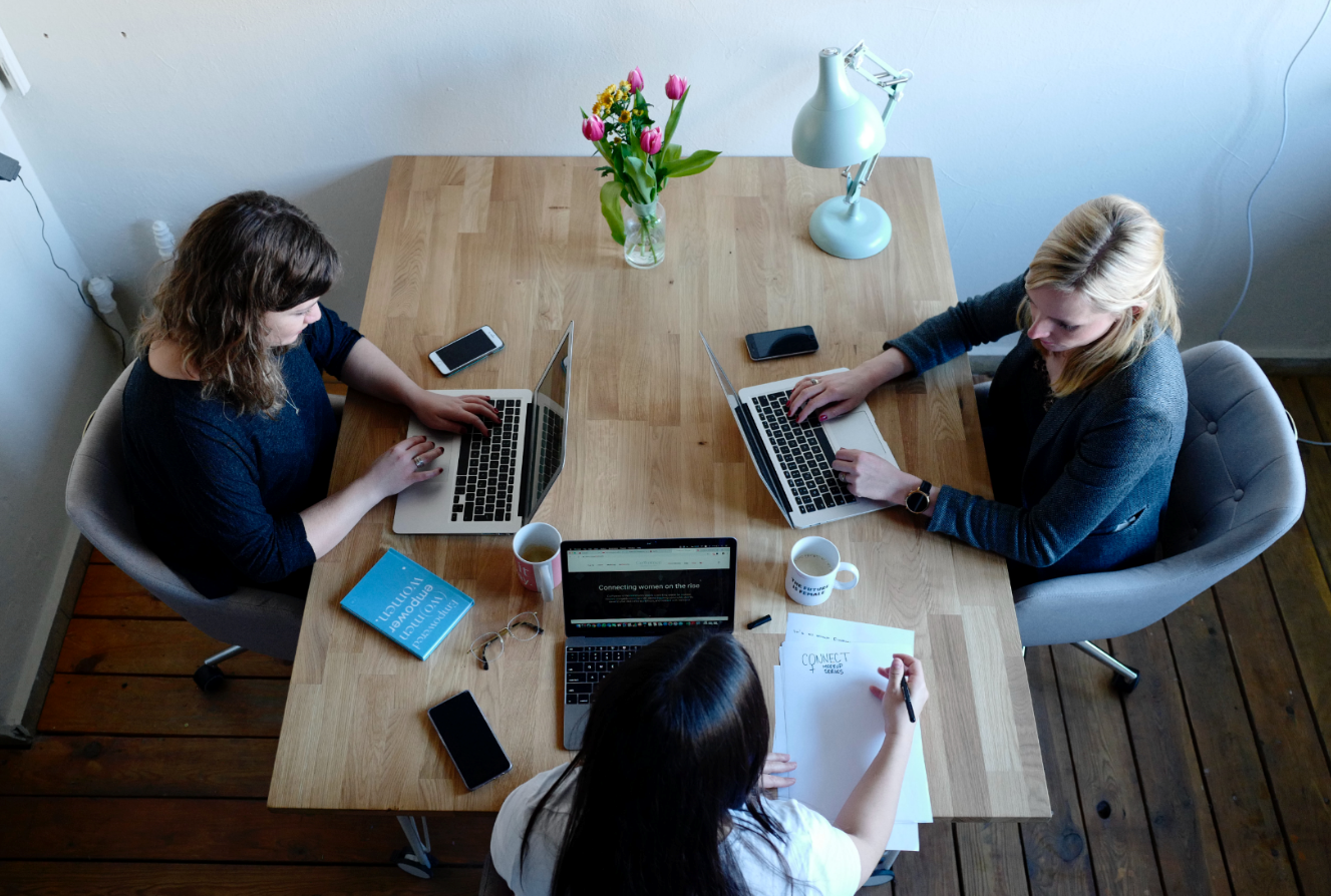 3 Lehrbeauftragte mit ihren Arbeitsmaterialien bei der Unterrichtsvorbereitung bzw. beim Austausch
