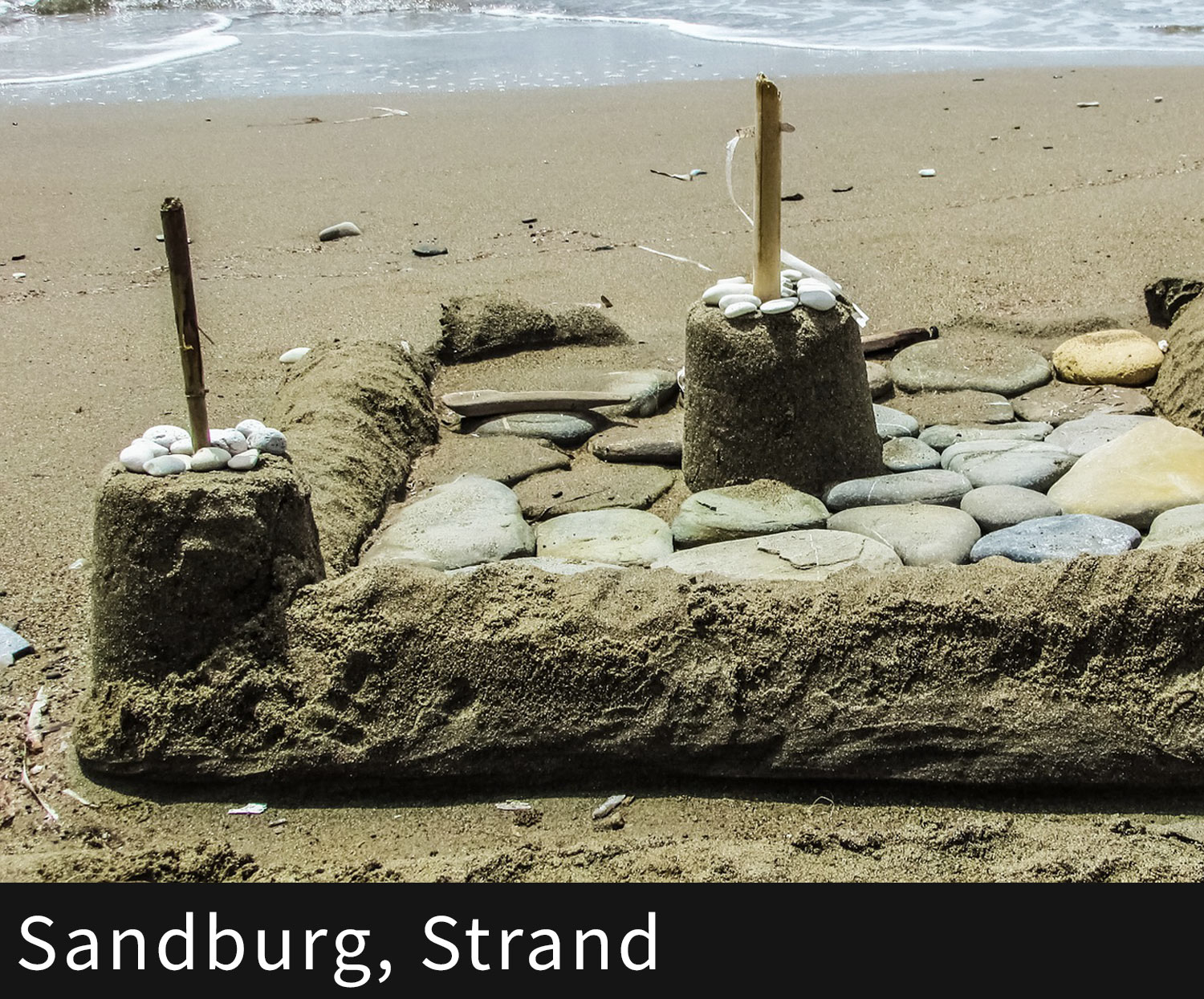 Blick auf eine Sandburg am Strand.