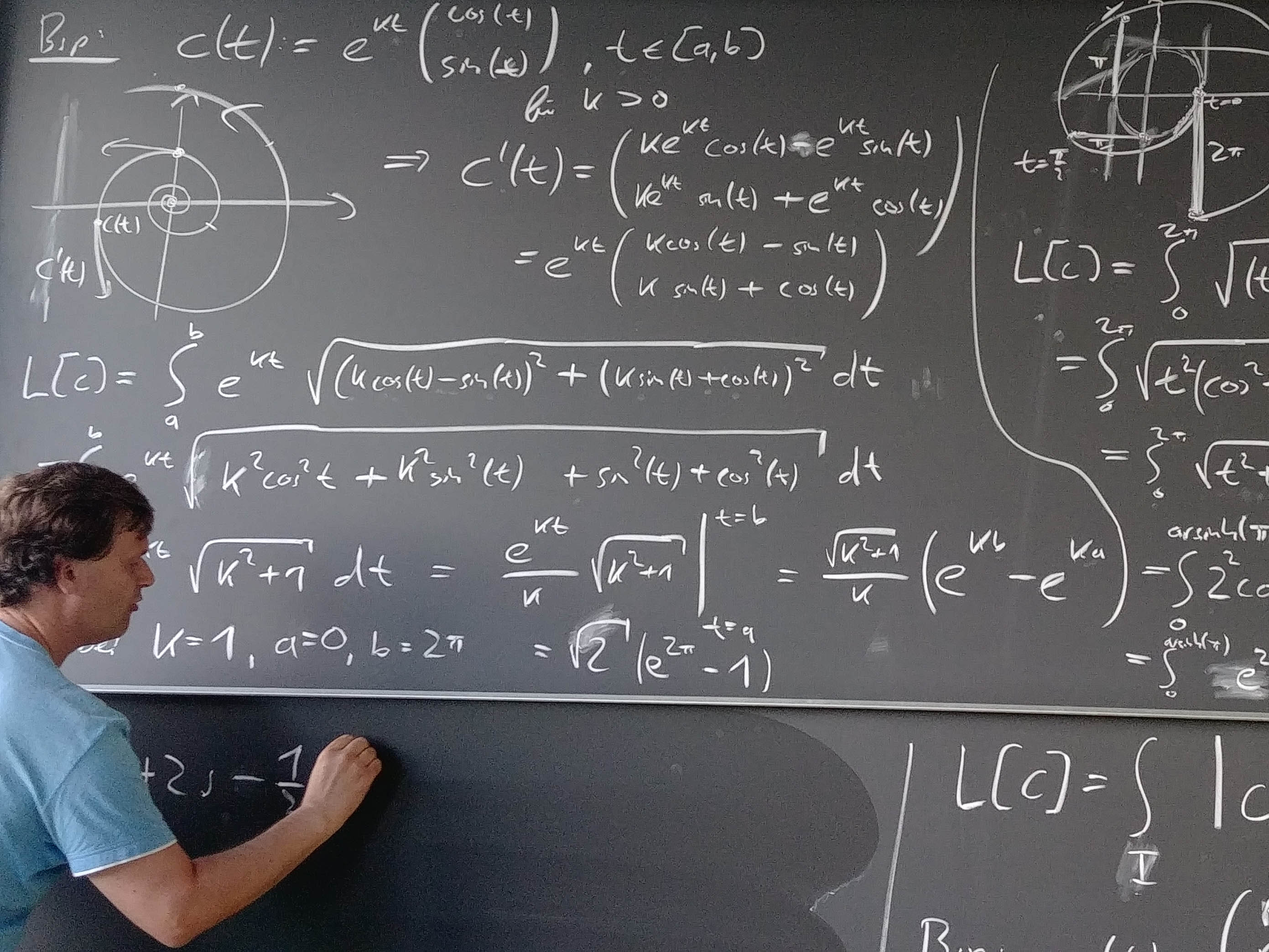 Ein Lehrender schreibt an eine Tafel komplexe mathematische Formeln.
