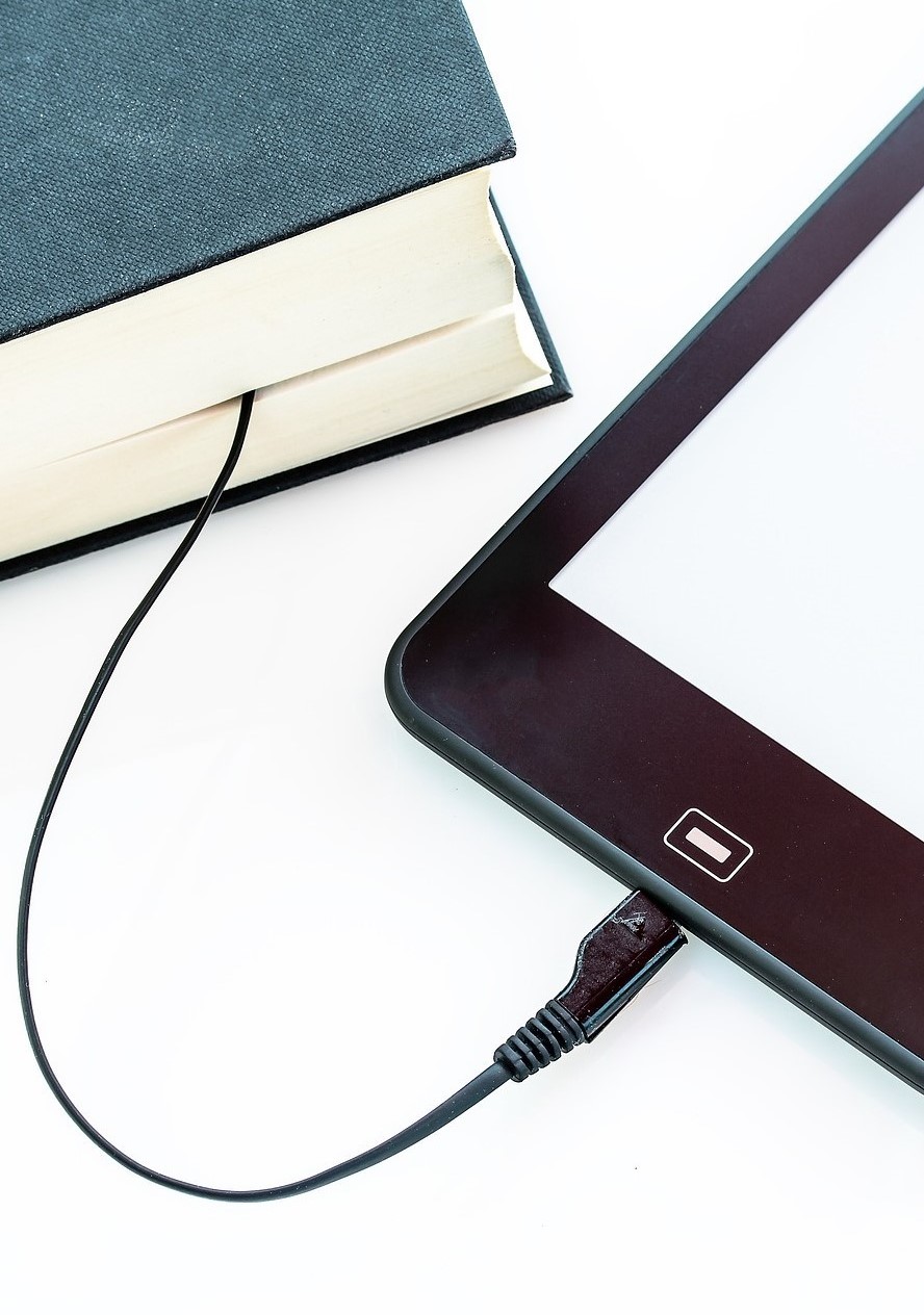 Illustration eines Buches und Handys, welche mit einem Kabel miteinander verbunden sind.